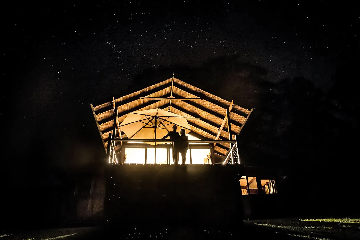 Couple on a chalet deck beneath stars