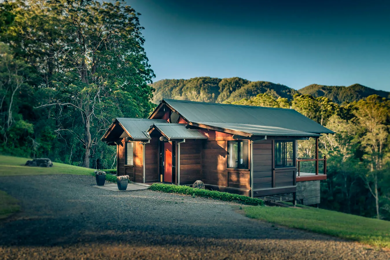 The Ridge chalet at golden hour — mountains glowing amber behind the timber structure