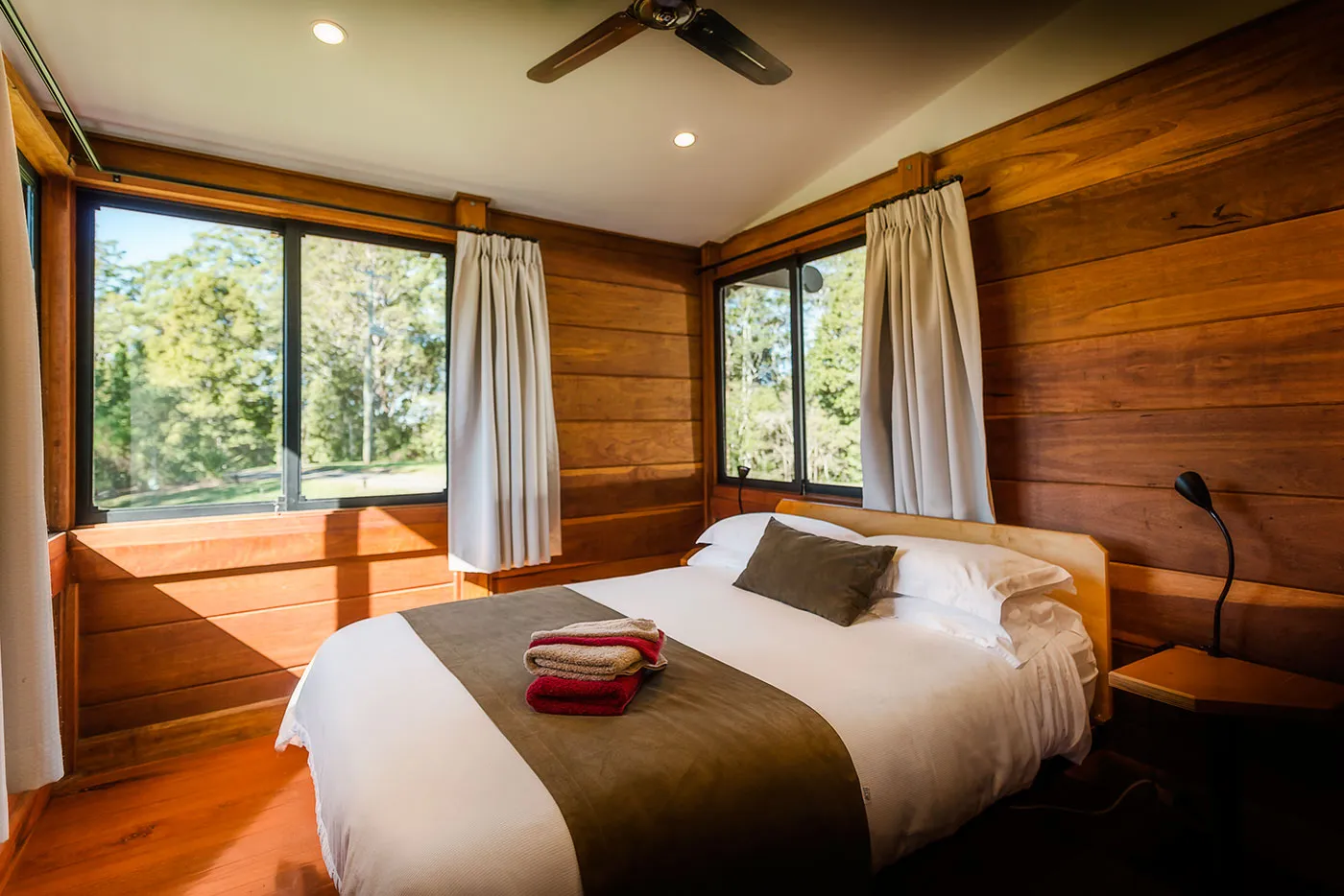 Tallowood bedroom — queen bed, timber walls, mountain light