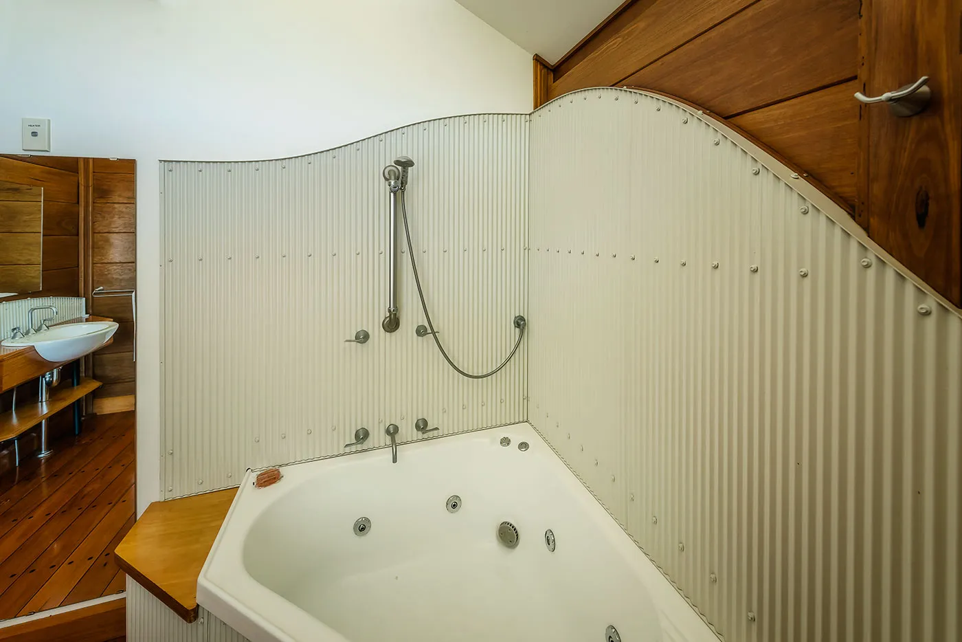 The Ridge bathroom — spa bath, clean lines, natural timber