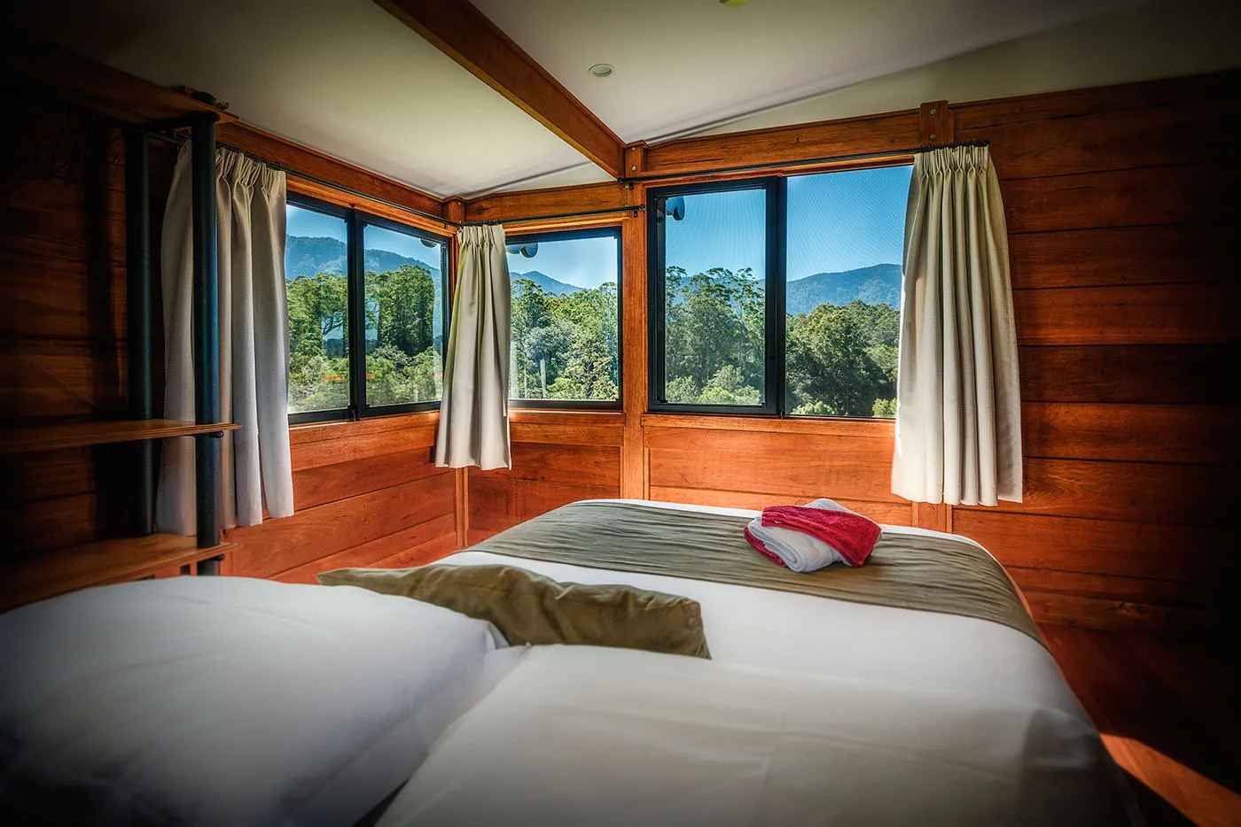 The Ridge master bedroom — queen bed, timber walls, soft light